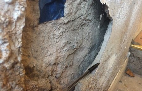 Blown plaster due to moisture trapped on this interior wall, with monitoring equipment fitted by Historic England