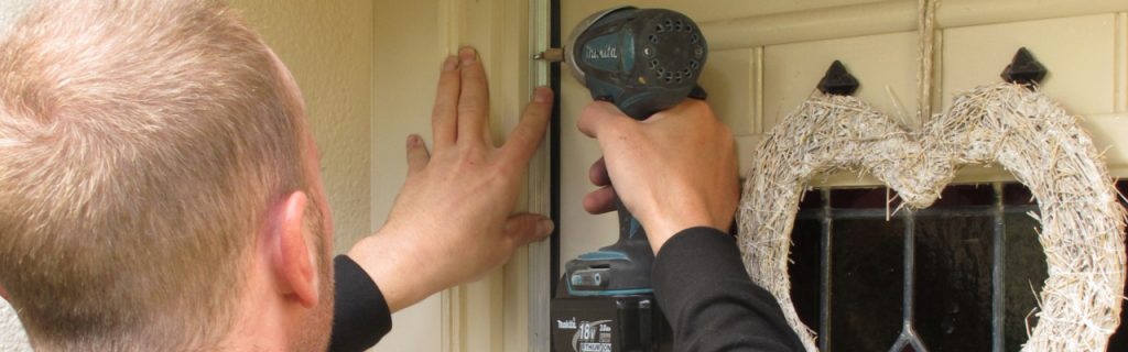 An installer fitting a door seal in Cumbria - CAfS draughtproofing scheme