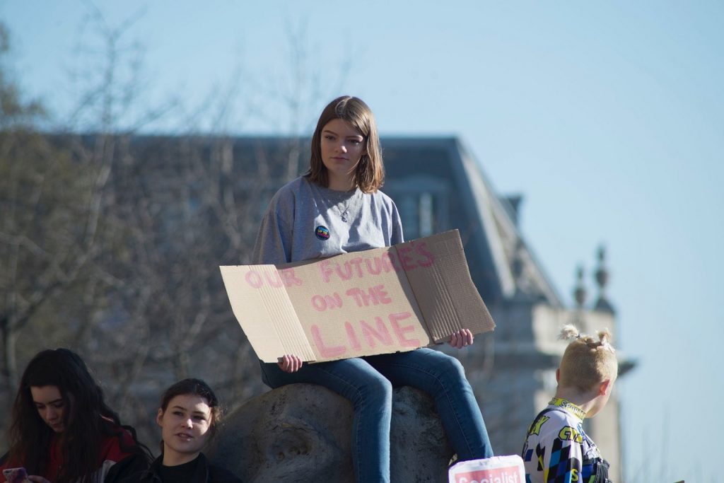 Young person with a climate change banner - Photo by Josh Barwick on Unsplash