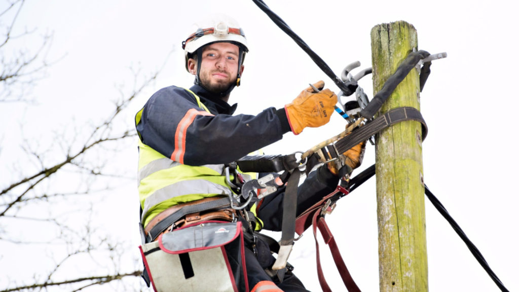 Electricity North West engineer working on cables at the top of an electricity pole