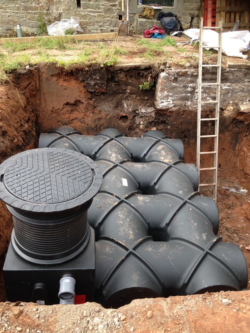 The below-ground rainwater harvesting tank at a straw-bale new-build home at Brampton