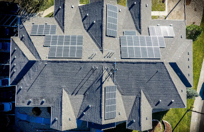 A large house from above with solar panels on the roof