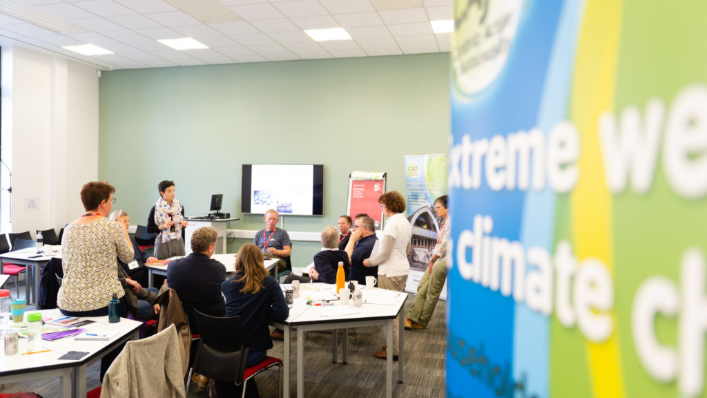 Room of people brainstorming with a banner about climate change
