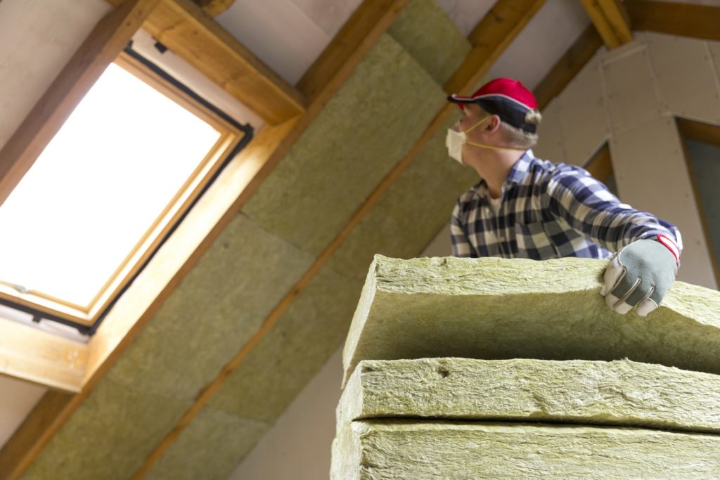 A man fitting insulation in a loft. Insulation and double glazing are among the measures covered by the new Green Homes Grant