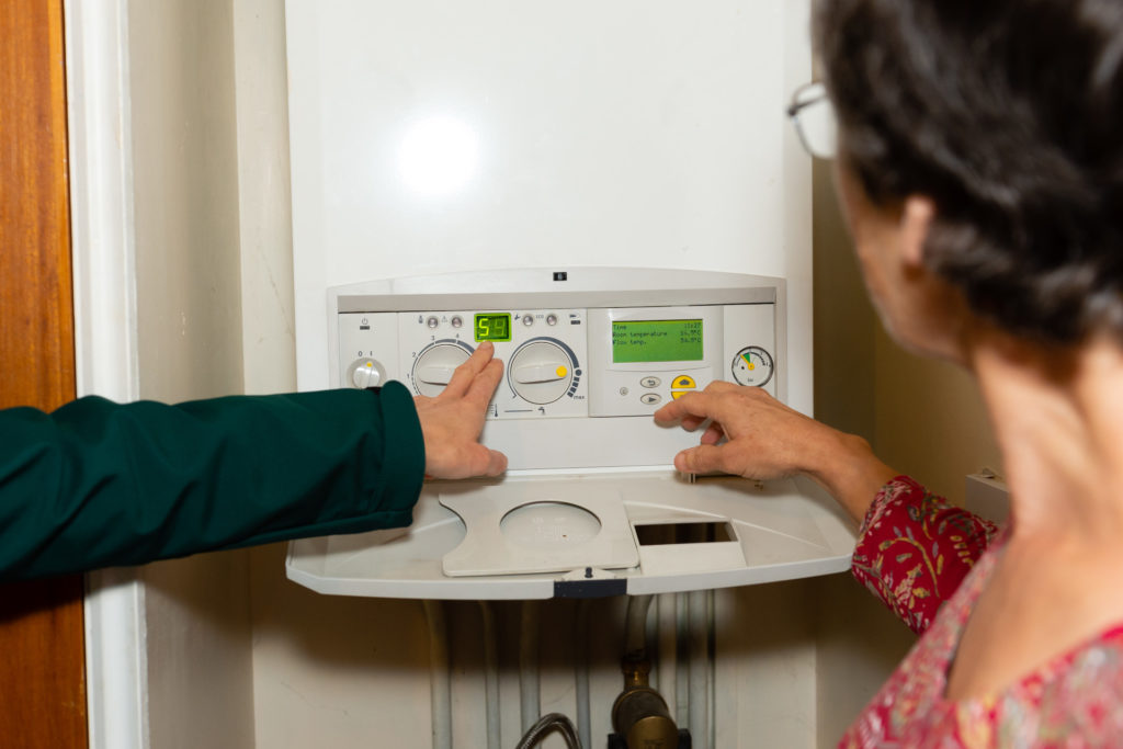 Finger pointing to the scale on a boiler