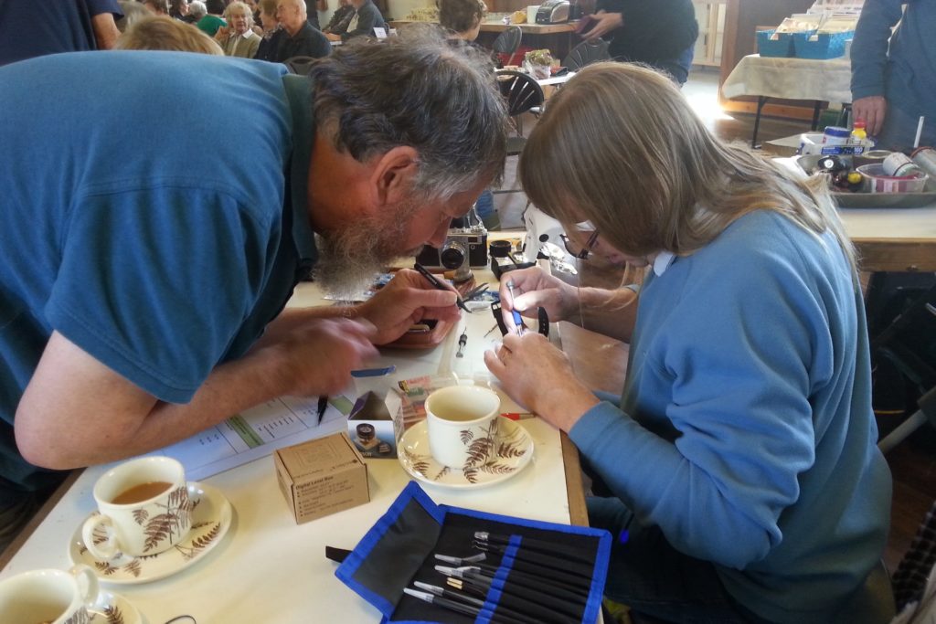 Two volunteers at Alston Moor Repair Cafe fixing an item