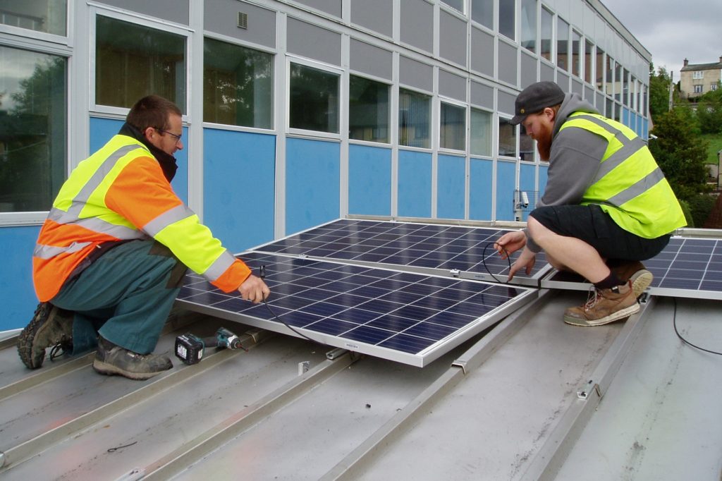 Two men on a roof installing solar panels in Alston, Cumbria