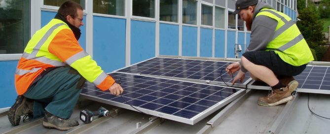 Two men on a roof installing solar panels in Alston, Cumbria