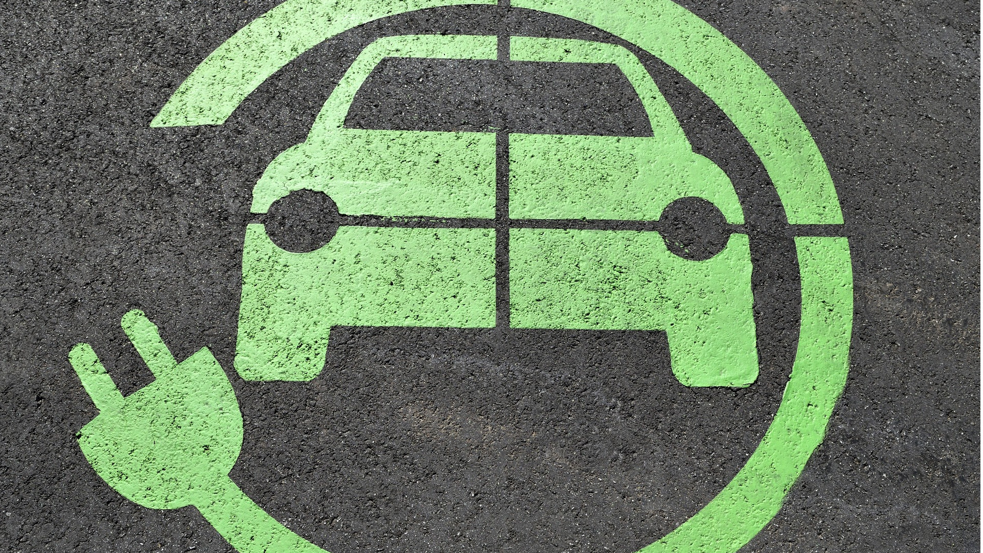 Electric vehicle charging icon on tarmac
