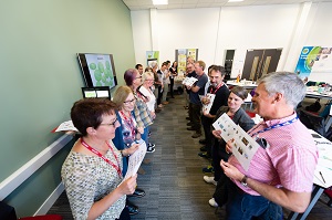 Two rows of attendees at a CAfS carbon literacy course in Carlisle, facing each other and holding up sheets