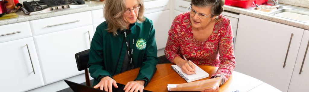 Cafs staff helping customer with energy bills on laptop