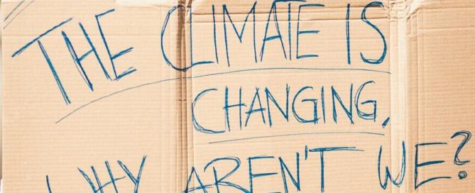 A cardboard protest banner saying: The climate is changing. Why aren't we?