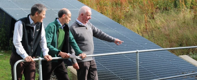 Three men standing near a hydro power station
