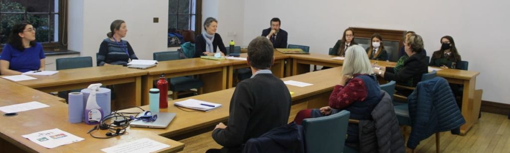 A room of councillors talking with school pupils