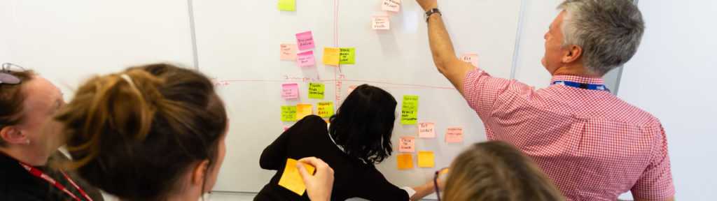 sticking post it notes on a whiteboard during a carbon literacy course